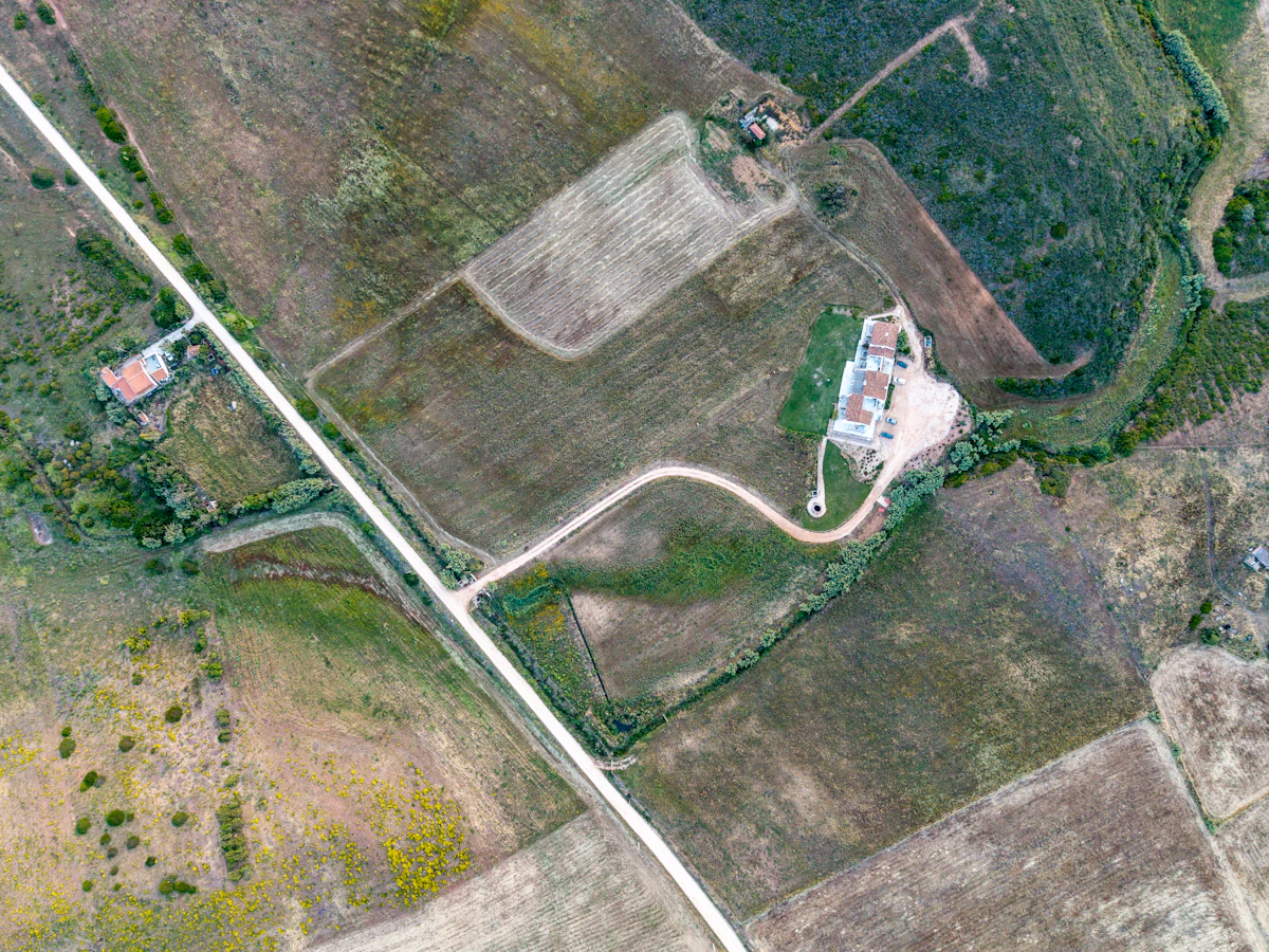 Aerial view of a rural homestead with farm buildings and fields