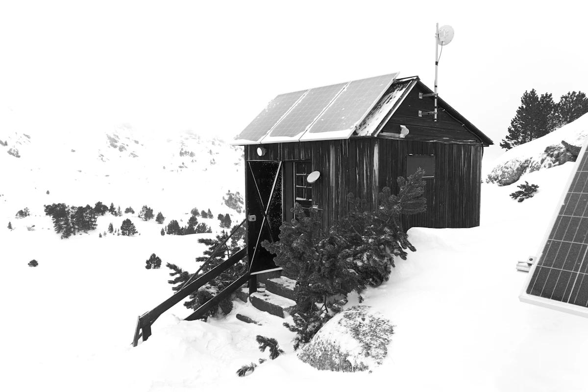 An off-grid cabin with roof-mounted solar panels in a mountain setting